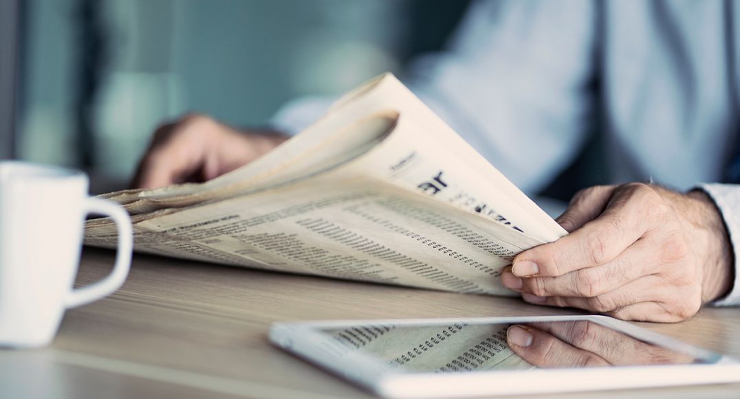 Hands holding a newspaper