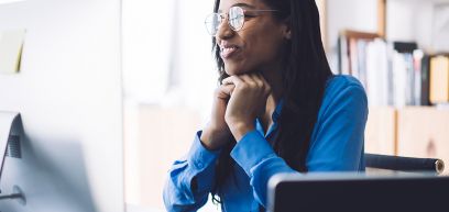 Woman with glasses staring at a computer